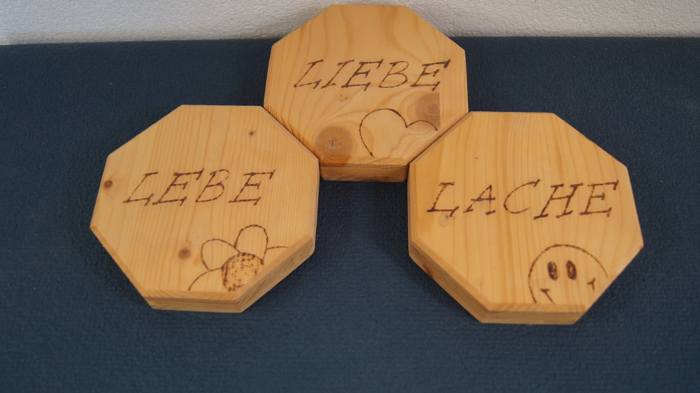 Drei achteckige Holzschilder von LEÑA Kunsthandwerk mit Brandmalerei: Liebe, Lebe, Lache